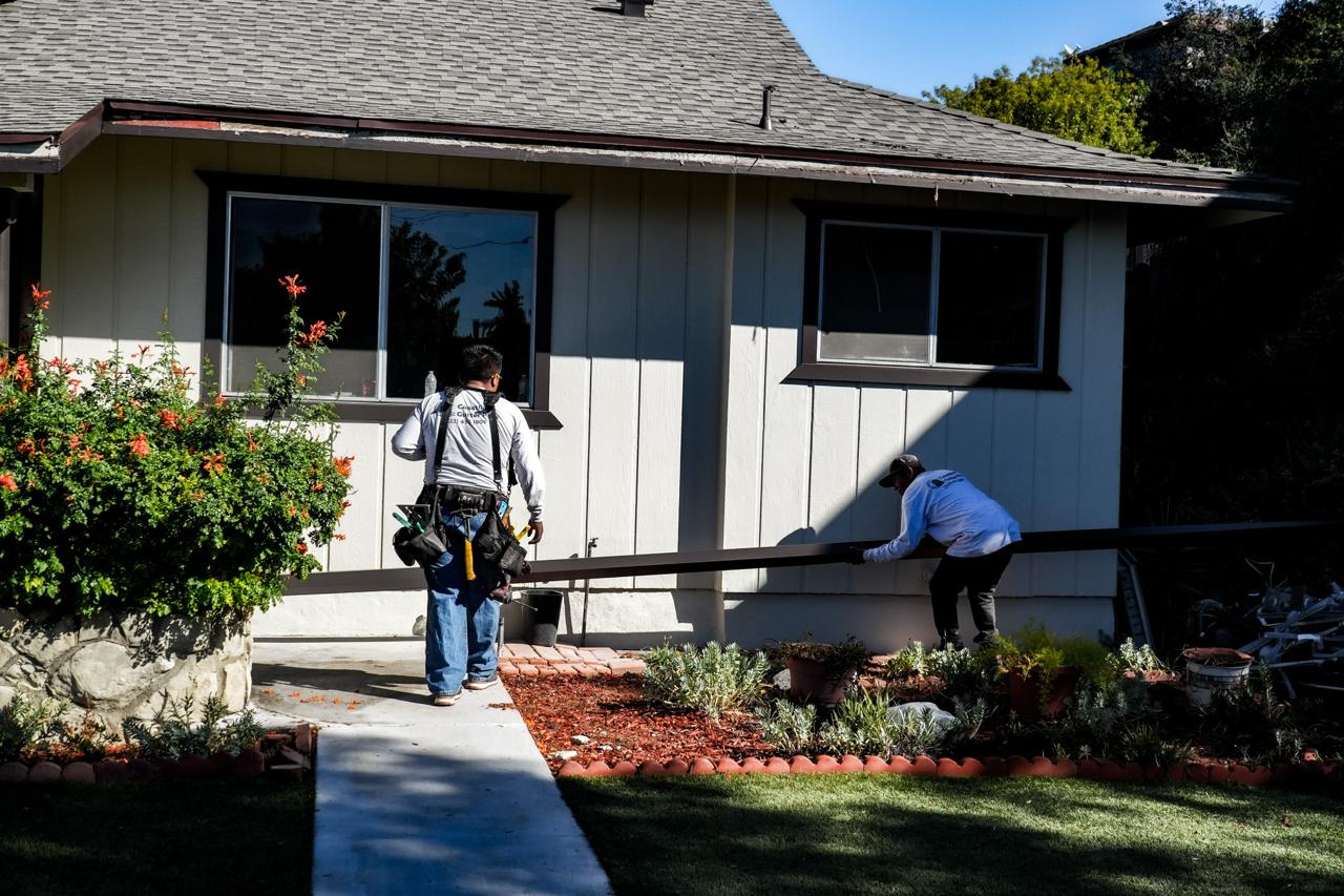 Two Coastline installers working on a gutter at a Los Angeles home.