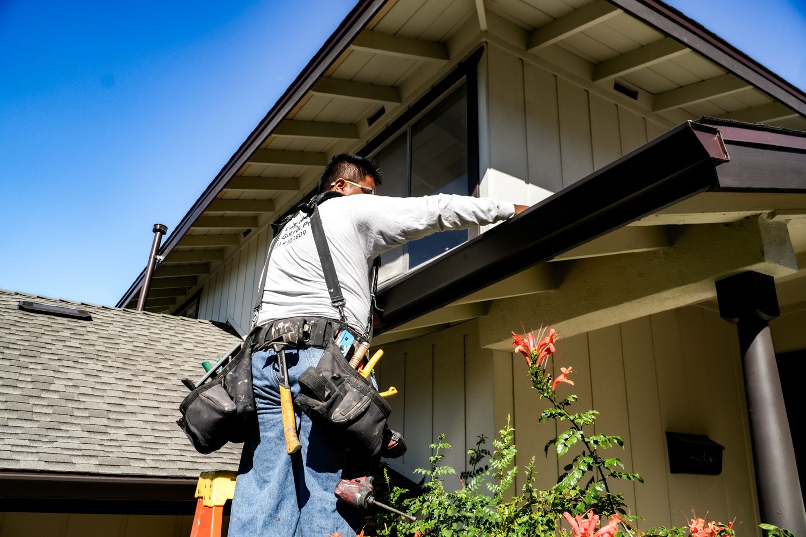 Coastline installer mounting a brown K-style gutter to fascia on a Los Angeles home.